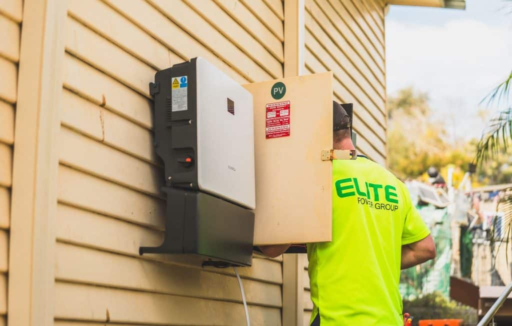 Solar power inverter installed on a house exterior wall for renewable energy.