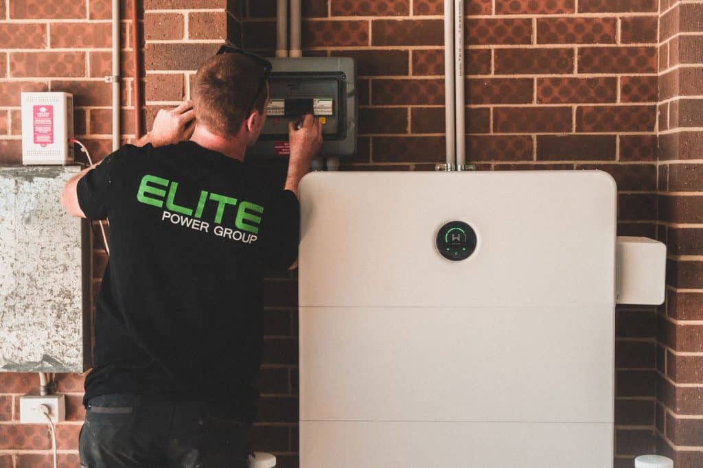 Electrician installing a home energy battery storage unit. Renewable and sustainable energy solution for residential use