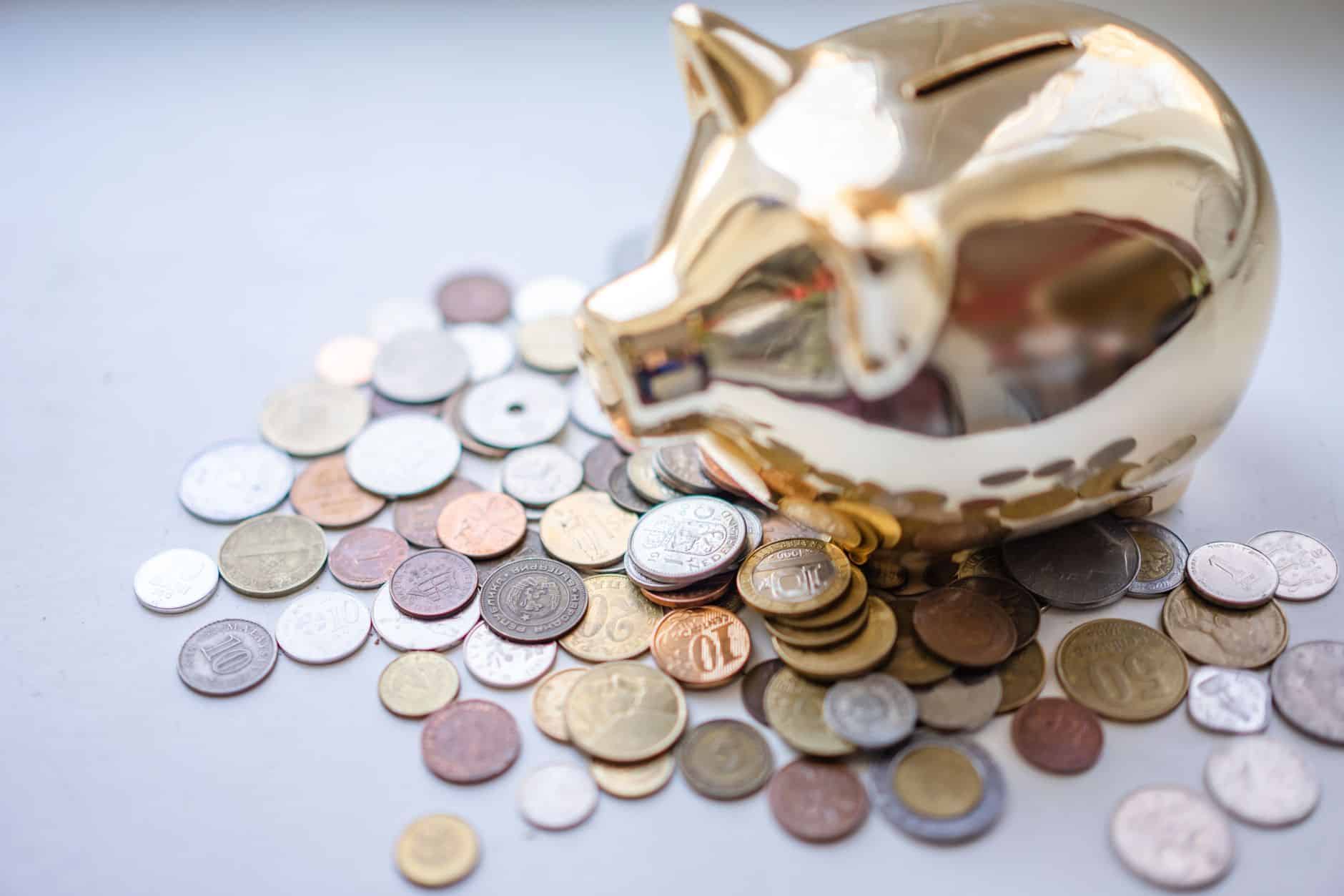 A golden piggy bank surrounded by assorted coins, symbolizing savings and wealth.