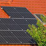 Solar panels installed on a red tiled roof for renewable energy.